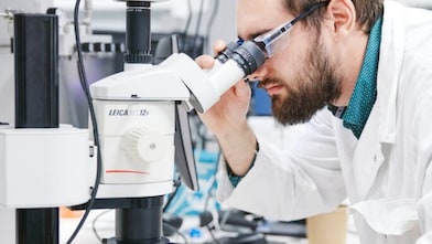 person looking into a microscope